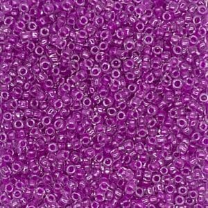 Close-up of numerous small purple beads with holes.
