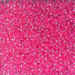 A close-up of numerous small pink beads with a shiny finish.