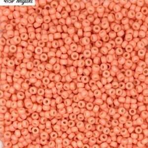 Close-up of tiny coral-colored seed beads densely packed.
