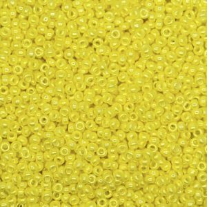 Close-up of small, yellow seed beads with central holes.
