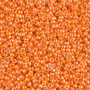 Close-up of numerous small, shiny orange beads.