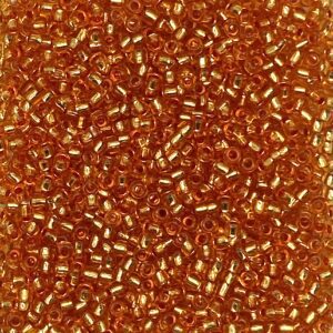 Close-up of small amber-colored glass beads with white stripes.