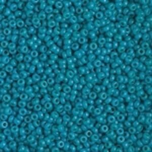 Close-up of small turquoise beads with a hole in the center.