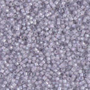 Close-up of small translucent plastic pellets with a purple tint.