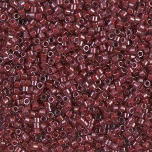 Close-up of tiny maroon seed beads with a shiny finish.