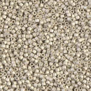 Close-up of numerous small, light gray cylindrical beads with holes.