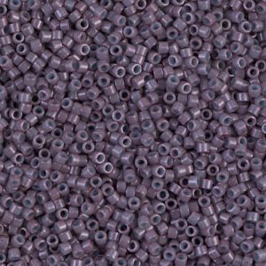 Close-up of small purple seed beads with holes in the center.