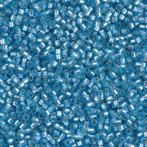 Close-up of small blue glass beads with silver linings.