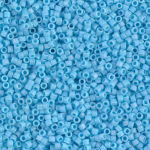 Close-up of small, light blue cylindrical beads scattered densely.