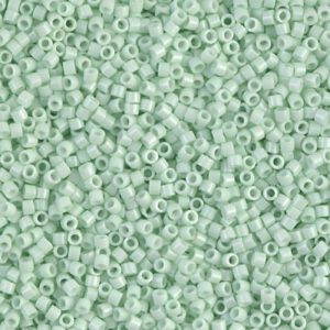 Close-up of mint green seed beads with a matte finish.