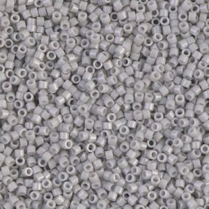 Close-up of small, light gray seed beads scattered densely.