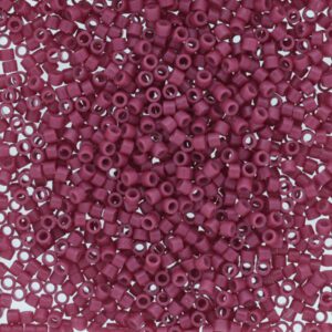 Close-up of small, round, purple beads with holes in the center.