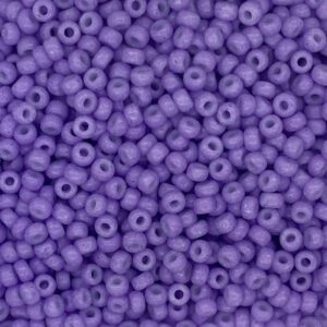 Close-up of small purple beads with holes in the center.