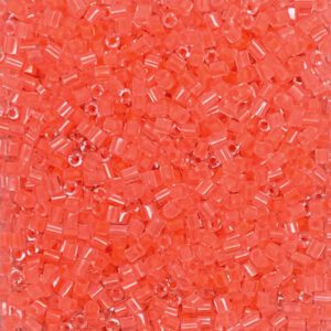 Small coral-colored glass seed beads close-up.