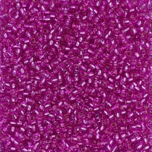 Pink seed beads scattered in close-up view.