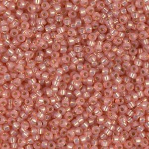 Pink seed beads scattered in a pile.